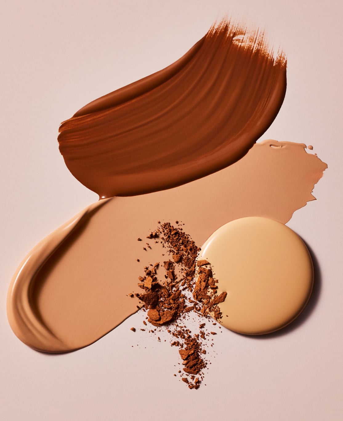different estee lauder foundation textures on a smooth beige surface