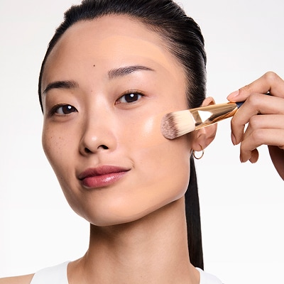 woman applying long lasting makeup from estee lauder